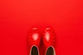 Top view of watertights rain season concept. new children`s stylish gumboots on red background. overhead photo of red watertights