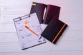 Top view week calendar with pen and black copybook.