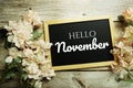 Welcome November text message on blackboard with flower decoration on wooden background Royalty Free Stock Photo