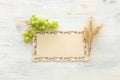 Top view of wheat crops and green grapes over white wooden background. Symbols of jewish holiday - Shavuot