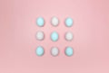 Top view of white and blue eggs on pink background. Creative easter composition, flat lay, copy space. Royalty Free Stock Photo