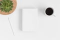 Top view of a white book mockup with workspace accessories and a succulent plant on a white table Royalty Free Stock Photo