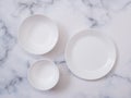 Top view of white ceramic plate or round dish, bowl and crockery set on mable table