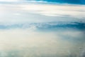 Top view of white clouds between which you can see high mountains Royalty Free Stock Photo