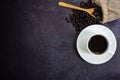 Top view, white cup of black coffee and dark  roasted beans with wooden spoon Royalty Free Stock Photo