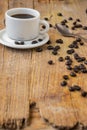 Top view of white cup of coffee, on rustic wooden table with coffee beans and spoon, selective focus Royalty Free Stock Photo