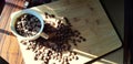 top view with white cup filled with freshly roasted coffee beans isolated on wood plank Royalty Free Stock Photo