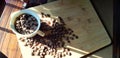 top view with white cup filled with freshly roasted coffee beans isolated on wood plank Royalty Free Stock Photo