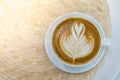 Top view of white cup of hot coffee latte with milk foam heart shape art on round table and copy space Royalty Free Stock Photo