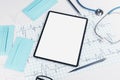 Top view of white desk with empty pad, stethoscope, cardiogram, pen, other items and mock up place. Doctor`s office, workplace an Royalty Free Stock Photo