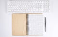 Top view of white desk with keyboard and notebook. Copy space Royalty Free Stock Photo