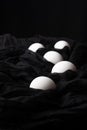 Top view of white eggs on black cloth, with selective focus and vertical black background,