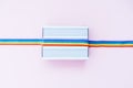 Top view white light box mockup with rainbow LGBT ribbon on a light pink background. Copy space for text or design Royalty Free Stock Photo