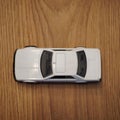 Top view of a white Mattel Hot Wheels toy car on a wooden surface