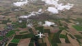 Brandless passenger plane flying above countryside