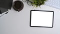 Top view of office desk with mack up digital tablet, coffee cup, house plant and notebook. Royalty Free Stock Photo