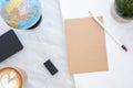 Top view of white pencil on brown paper with blue globe,blackboard,coffee cup and plant on marble table.new yearÃ¢â¬â¢s resolutions