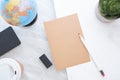 Top view of white pencil on brown paper with blue globe,blackboard,coffee cup and plant on marble table.new yearÃ¢â¬â¢s resolutions Royalty Free Stock Photo