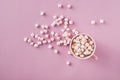 Top view of white and pink marshmallows in mug