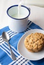 Top view of white plate with chocolate chip cookies, cup, spoon and bottle of milk, on blue napkin, white table Royalty Free Stock Photo