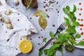 Closeup of a table with bay leaves, green salad leaves, quail eggs, a half of lemon on a light gray background.