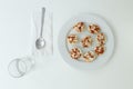 Top view of a white plate of mini pizza bagels on white background
