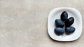 Top view of a white plate with plums, place for text near a plate with blue fruits Royalty Free Stock Photo