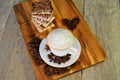 Top view of a white porcelain cappuccino cup standing on a wooden cutting board.  A stack of chocolate pieces of various kinds Royalty Free Stock Photo