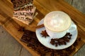 Top view of a white porcelain cappuccino cup standing on a wooden cutting board.  A stack of chocolate pieces of various kinds Royalty Free Stock Photo