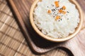 Top view of white rice in wooden bowl with sesame seeds and carrot on wood board Royalty Free Stock Photo