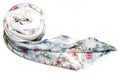 Top view of a white rolled up scarf with floral design on a white surface Royalty Free Stock Photo