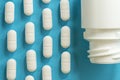 Top view of a  white rounded pills and plastic bottle on blue Royalty Free Stock Photo
