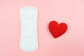 Top view white sanitary napkin and red heart isolated on pink background. Woman hygiene, Concept of critical days, menstruation, Royalty Free Stock Photo