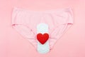 Top view white sanitary napkin,red heart and pink underpants isolated on pink background. Woman hygiene, Concept of critical days Royalty Free Stock Photo