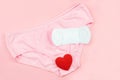 Top view white sanitary napkin,red heart and pink underpants isolated on pink background. Woman hygiene, Concept of critical days Royalty Free Stock Photo