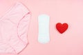 Top view white sanitary napkin,red heart and pink underpants isolated on pink background. Woman hygiene, Concept of critical days Royalty Free Stock Photo