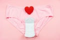 Top view white sanitary napkin,red heart and pink underpants isolated on pink background. Woman hygiene, Concept of critical days