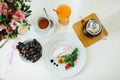 Top view of a white table with a glass teapot, a cup of tea and a glass of juice. White plate with a croissant and two Royalty Free Stock Photo