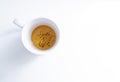 top view of a white tea cup on a white background with some tea infusion and tea grounds in the bottom of the cup, roiboos,