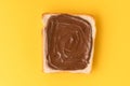 Top view of white toast bread with chocolate hazelnut spread on the yellow background. Morning breakfast concept. Food mockup with Royalty Free Stock Photo