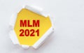 Top view of white  torn paper and text mlm - multilevel marketing on yellow background Royalty Free Stock Photo