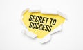 Top view of white torn paper and the text Secret to Success on a yellow background