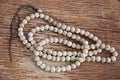 Top view of white wooden buddhist bracelet on wooden background.