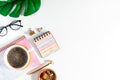 Top view of white working table background with cup of coffee putting on it. Flat lay glasses, leaf, golden paper binder clips, Royalty Free Stock Photo