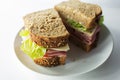 Top view of a whole ham and cheese sandwich on wheat bread, cut in half. Isolated on white background. Royalty Free Stock Photo