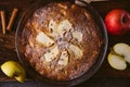 Top view of whole homemade apple pie on rustic brown burlap fabric with soft natural light, with apples and cinnamon sticks,