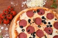 Top view of a whole pepperoni pizza with olives on a wooden board on the table Royalty Free Stock Photo