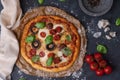 Top view of whole vegetarian pizza with mushrooms, basil, tomatoes, and cheese