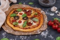 Top view of whole vegetarian pizza with mushrooms, basil, tomatoes, and cheese