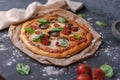 Top view of whole vegetarian pizza with mushrooms, basil, tomatoes, and cheese